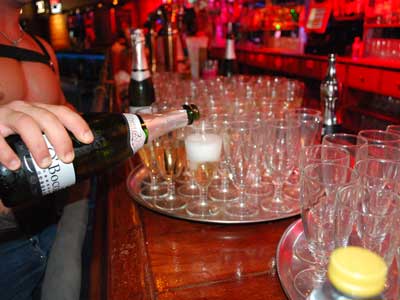 Free glass of cava served by sexy waiters